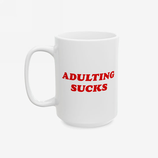 Adulting Sucks Mug with bold red lettering on white ceramic, expressing relatable frustration. Perfect for millennials facing daily challenges, this durable, dishwasher-safe mug supports Amnesty International. Available in 11 oz. and 15 oz.