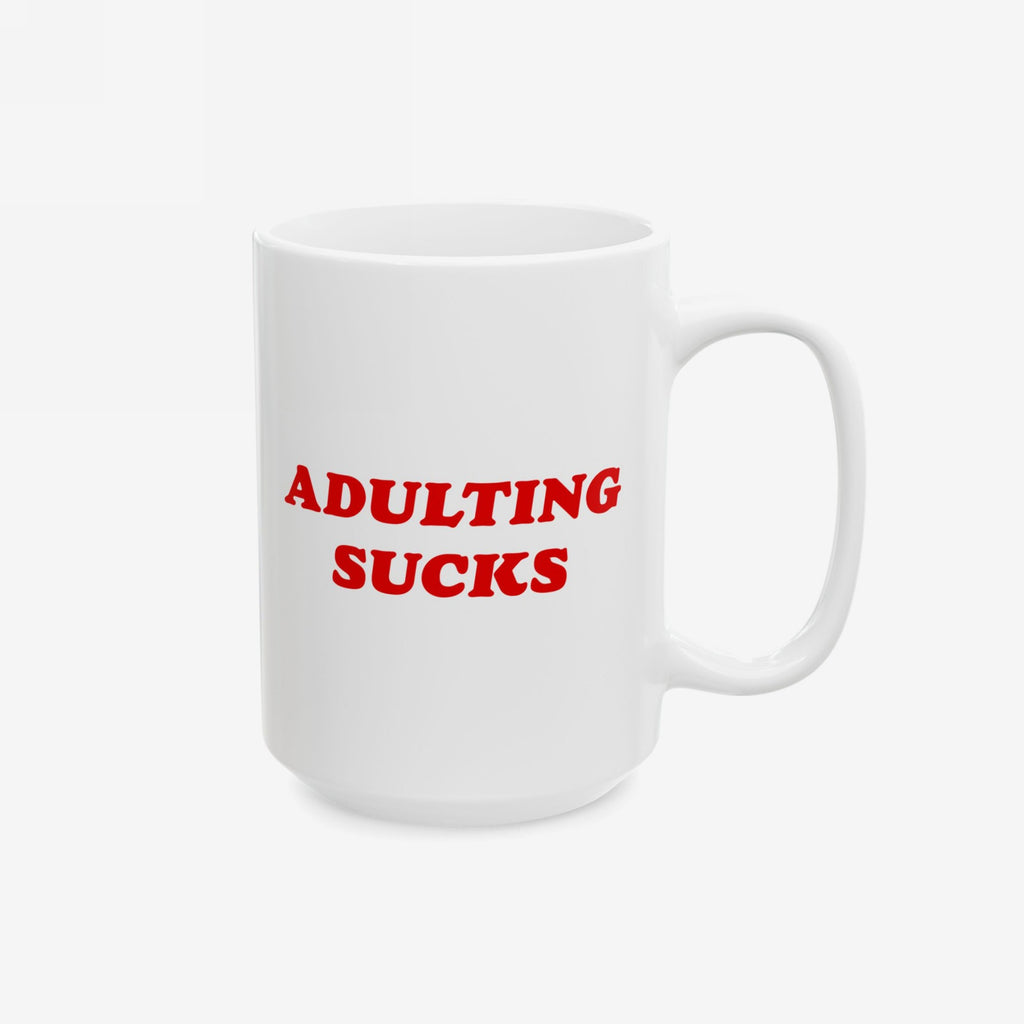 Straight-on view of white mug with red “Adulting Sucks” print, handle positioned on the right side