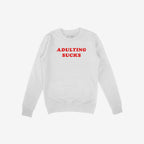 Adulting Sucks Shirt features a plain white crew-neck sweatshirt with bold red ADULTING SUCKS slogan, ribbed cuffs, and hem, offering humor and comfort for those navigating grown-up life.