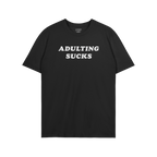 Black T-shirt featuring the slogan “ADULTING SUCKS” in white block letters, embodying humor and relatable self-expression