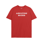 A red T-shirt with ADULTING SUCKS in bold white letters, reflecting humor and self-expression; part of a collection supportin