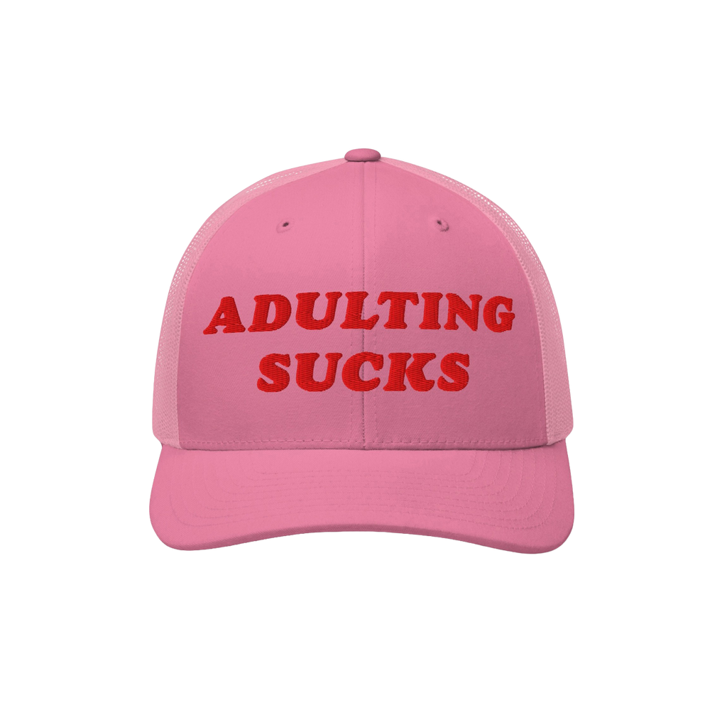 The Adulting Sucks Hat features bold red embroidery on a pink trucker-style cap, encapsulating the struggle against adult res