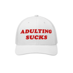 White mesh-back trucker hat with bold red embroidery stating “ADULTING SUCKS,” capturing a candid sentiment for millennia