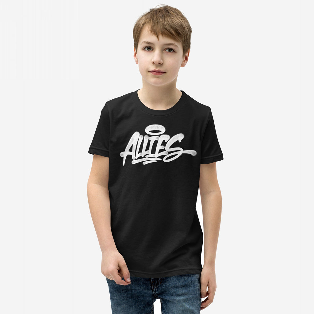 Young boy wearing the Allies Handstyle T-shirt, featuring a graffiti-style ALLIES graphic with a halo. A nod to solidarity and allyship, paired with blue jeans, embodying unity and support.