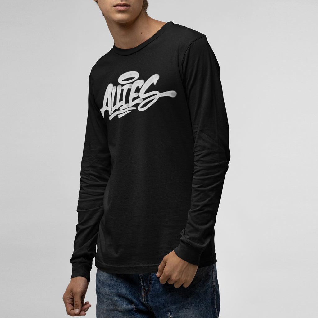 Person modeling the Allies Handstyle T-shirt, featuring a white graffiti-style ALLIES logo with a halo, symbolizing solidarity and support. Paired with blue jeans, against a light-gray backdrop.