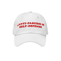 White unstructured baseball cap with bold red embroidery stating “ANTI-FASCISM IS SELF-DEFENSE.” Ideal for activists and 