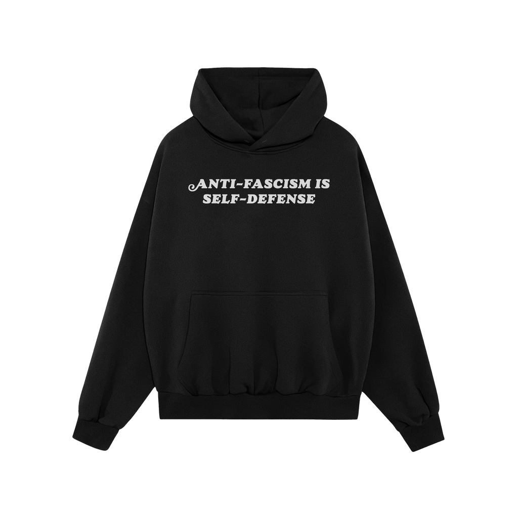 Black pullover hoodie featuring the bold slogan “ANTI-FASCISM IS SELF-DEFENSE” in white. The Anti Fascism Is Self Defense