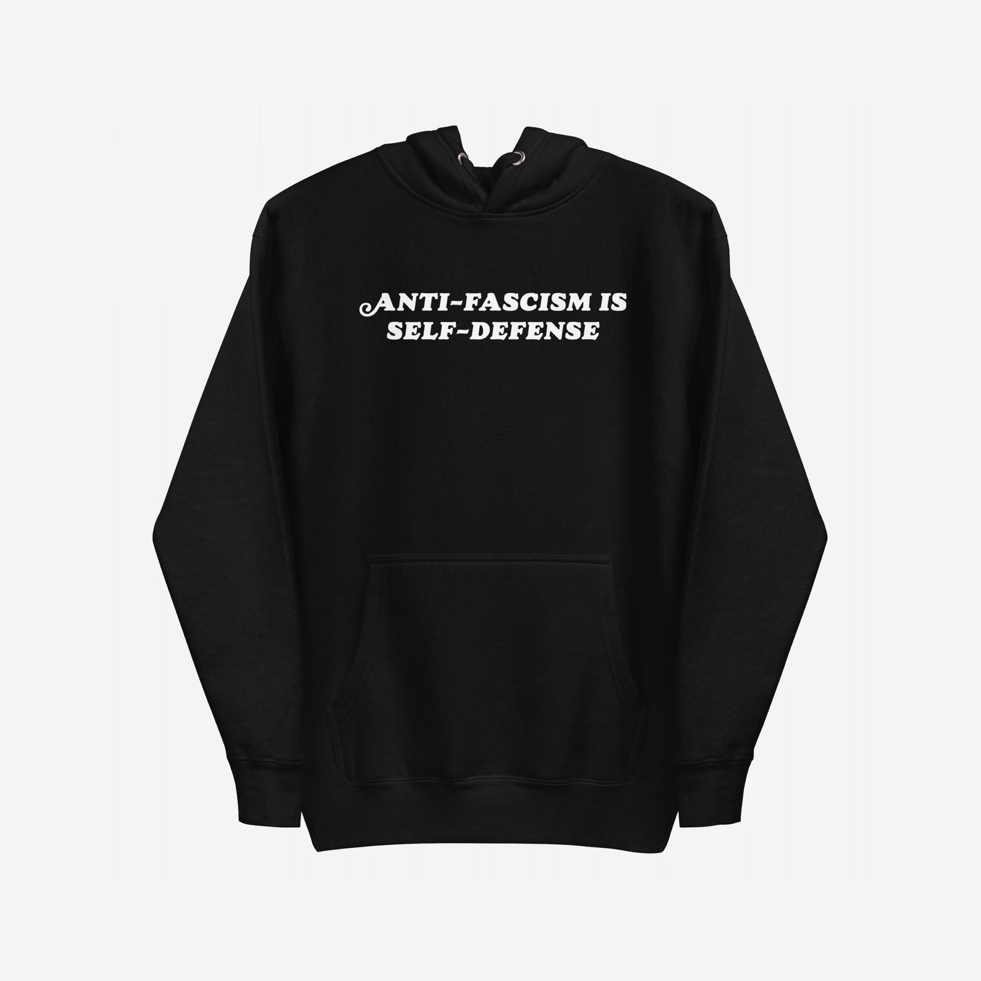 Black pullover Anti-Fascism Is Self-Defense Hoodie with a kangaroo pocket, featuring bold white text on the chest. Designed for those who stand against hate, it combines retro style with a powerful message.