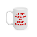 White ceramic Anti-Fascism Is Self-Defense mug with bold red text, featuring a standard C-handle and shiny finish, embodying 