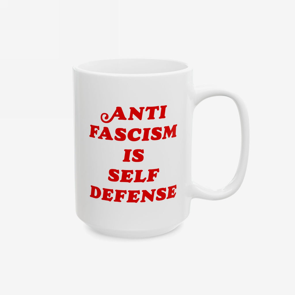 White ceramic mug with red text reading “ANTI FASCISM IS SELF DEFENSE,” embodying a bold message. Ideal for progressives, available in two sizes, supporting ACLU. Perfect for those who sip coffee with conviction.