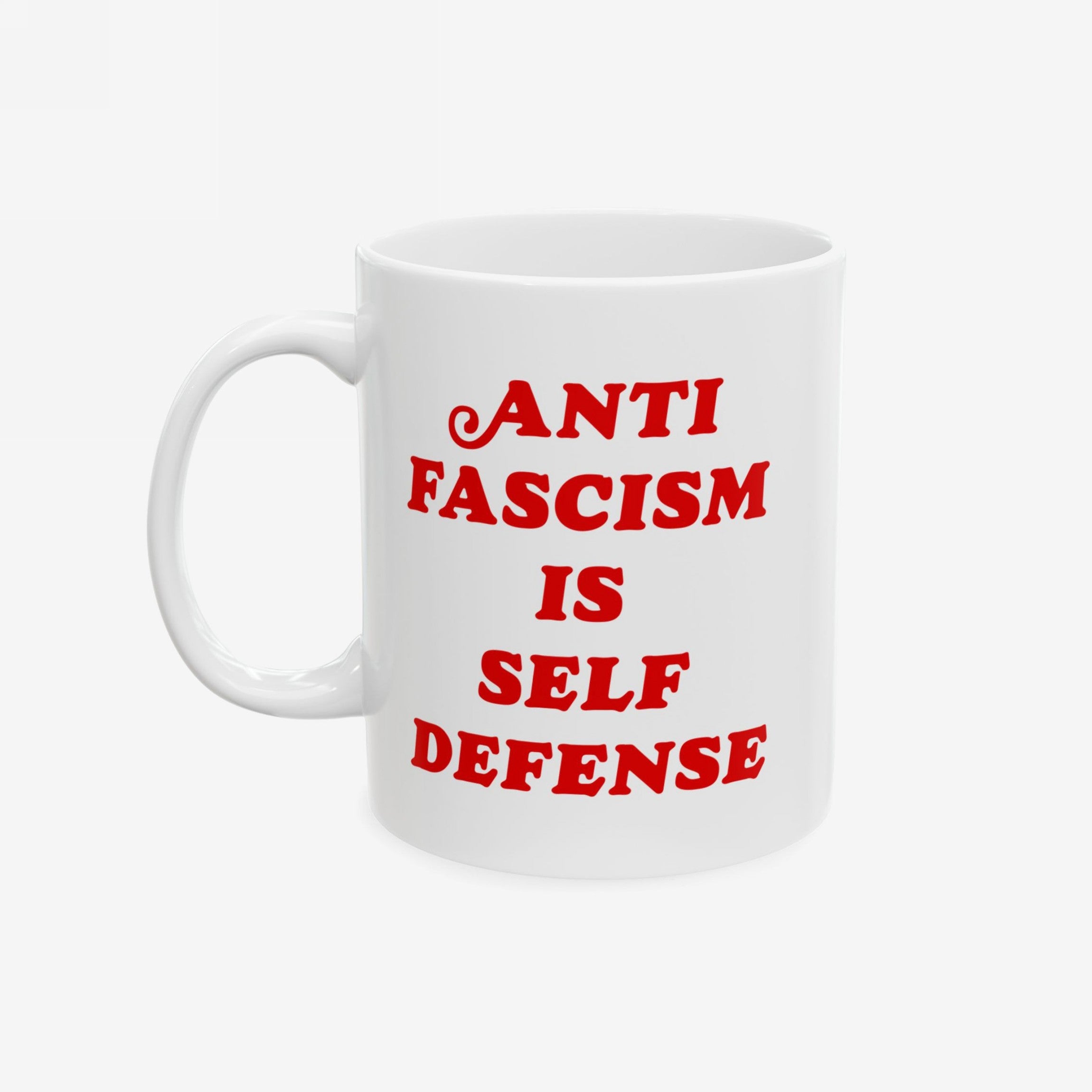 White ceramic mug with bold red text ANTI FASCISM IS SELF DEFENSE on the front, emphasizing strong political beliefs. Designed for those who oppose fascism, this mug supports ACLU donations.