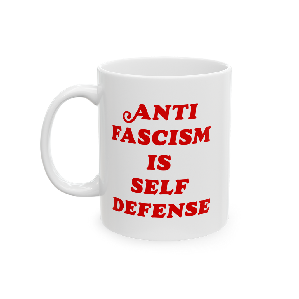 White ceramic mug with bold red text ANTI FASCISM IS SELF DEFENSE on the front, emphasizing strong political beliefs. Designe