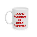 White ceramic mug with bold red text ANTI FASCISM IS SELF DEFENSE on the front, emphasizing strong political beliefs. Designe