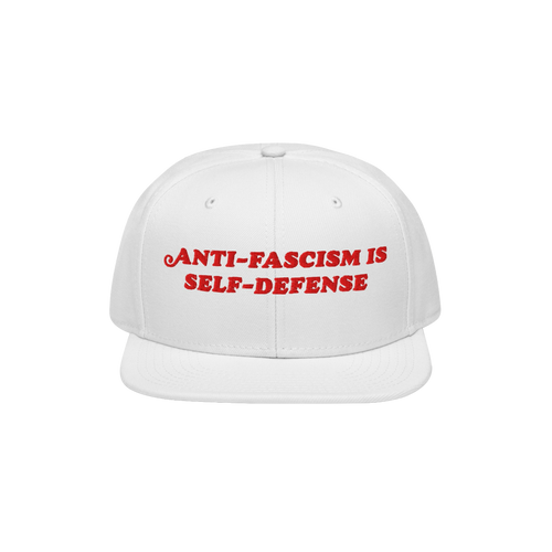 White flat-brimmed cap featuring bold red embroidery reading ANTI-FASCISM IS SELF-DEFENSE for activists and allies, embodying
