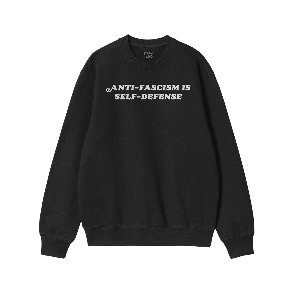 Black crewneck sweatshirt with “ANTI-FASCISM IS SELF-DEFENSE” in white on chest, reflecting activism and justice. Include
