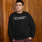 Person wearing Anti Fascism Is Self Defense Shirt with bold text, standing confidently. The black sweatshirt conveys a strong message of justice and resistance, aligning with values of activism and equality.
