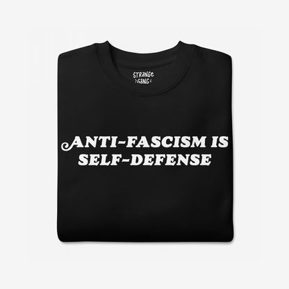 “Anti-Fascism Is Self-Defense” Hoodie & Sweatshirt featuring bold white lettering on black fabric, conveying a powerful message. Ideal for advocates, combining comfort with activism.