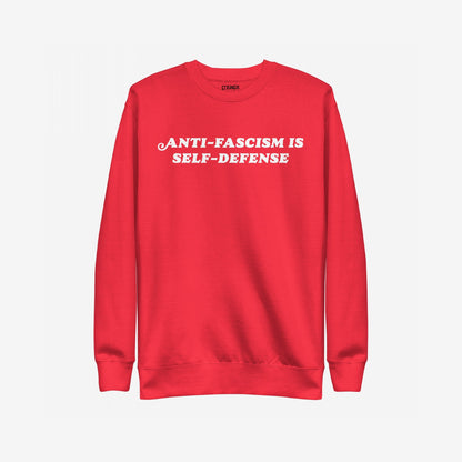 “Anti-Fascism Is Self-Defense” crewneck sweatshirt with bold white text, embodying resistance and equality against hate. Perfect for organizers and activists, reflecting a strong message with classic style.