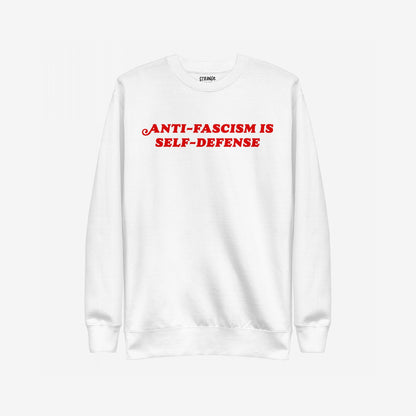Anti-Fascism Is Self-Defense Hoodie & Sweatshirt features bold red lettering on a plain white crewneck, delivering a strong anti-fascism message with a classic, straightforward design and ribbed cuffs.
