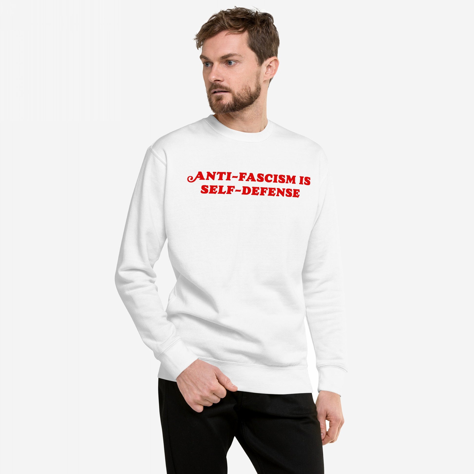 Model wearing Anti-Fascism Is Self-Defense Hoodie & Sweatshirt with bold red slogan, embodying a message of resistance and equality, standing against a plain backdrop.