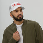 A bearded man models the Anti Fascism Is Self Defense Hat, featuring bold red embroidery on a white trucker cap, embodying a strong anti-fascist message.