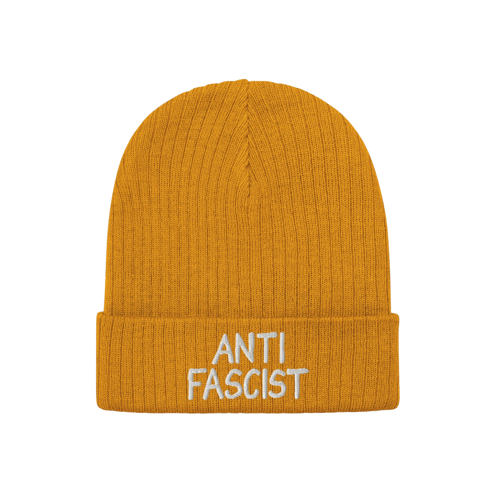 Anti Fascist Hat: A mustard-yellow, ribbed knit beanie with “ANTI FASCIST” embroidered in white on the cuff, embodying et