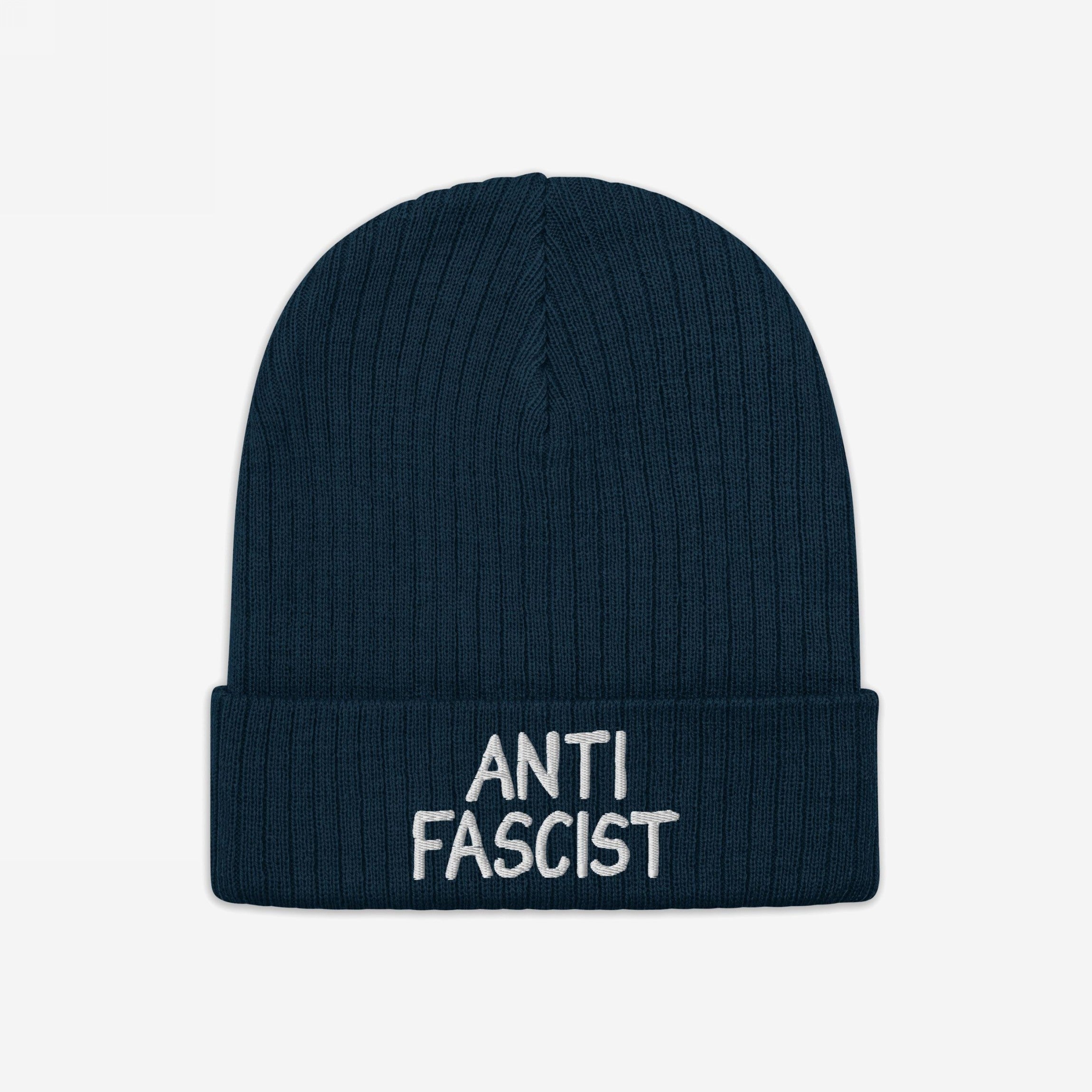 Dark navy-blue ribbed knit beanie with ANTI FASCIST embroidered in white on the cuff, embodying revolutionary style and ethical production for those who appreciate a good brim curve.