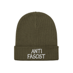 Anti Fascist Hat: An olive-green ribbed knit beanie with white ANTI FASCIST embroidery on the cuff, embodying a stylish, unis