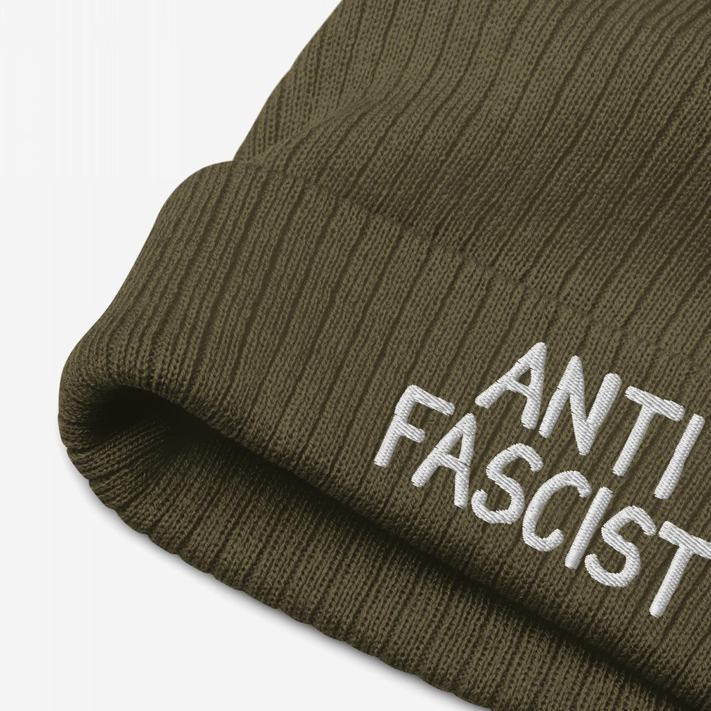 Close-up of the Anti Fascist Hat, an olive-green rib-knit beanie with ANTI FASCIST embroidered in white on the cuff, embodying style and activism against fascism.