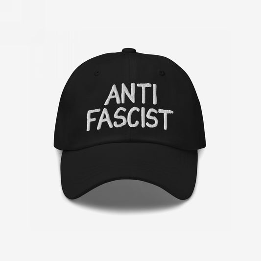 The Anti-Fascist Hat features ANTI FASCIST in white embroidery on a black cap, embodying a bold statement against oppression with a stylish, soft fit. Ethically made and gender-free.