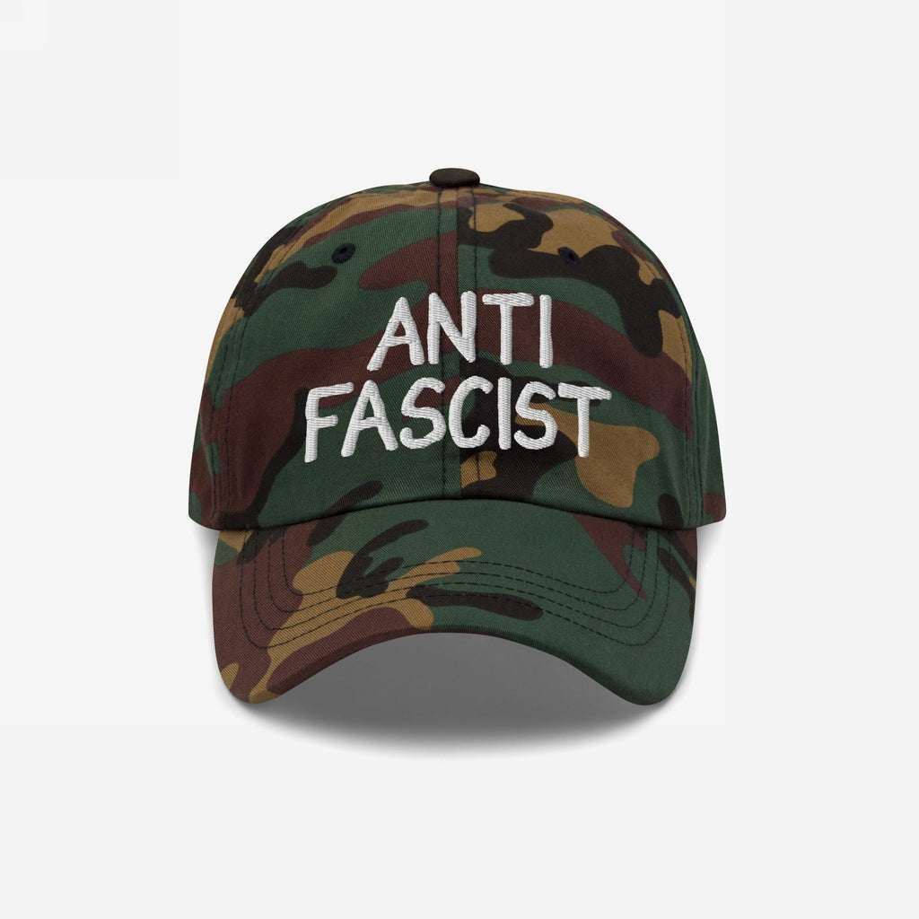 Woodland-camo baseball cap with ANTI FASCIST in white embroidery, combining style with activism. Ethically made, unisex, designed for comfort and impact. Proceeds support the ACLU.