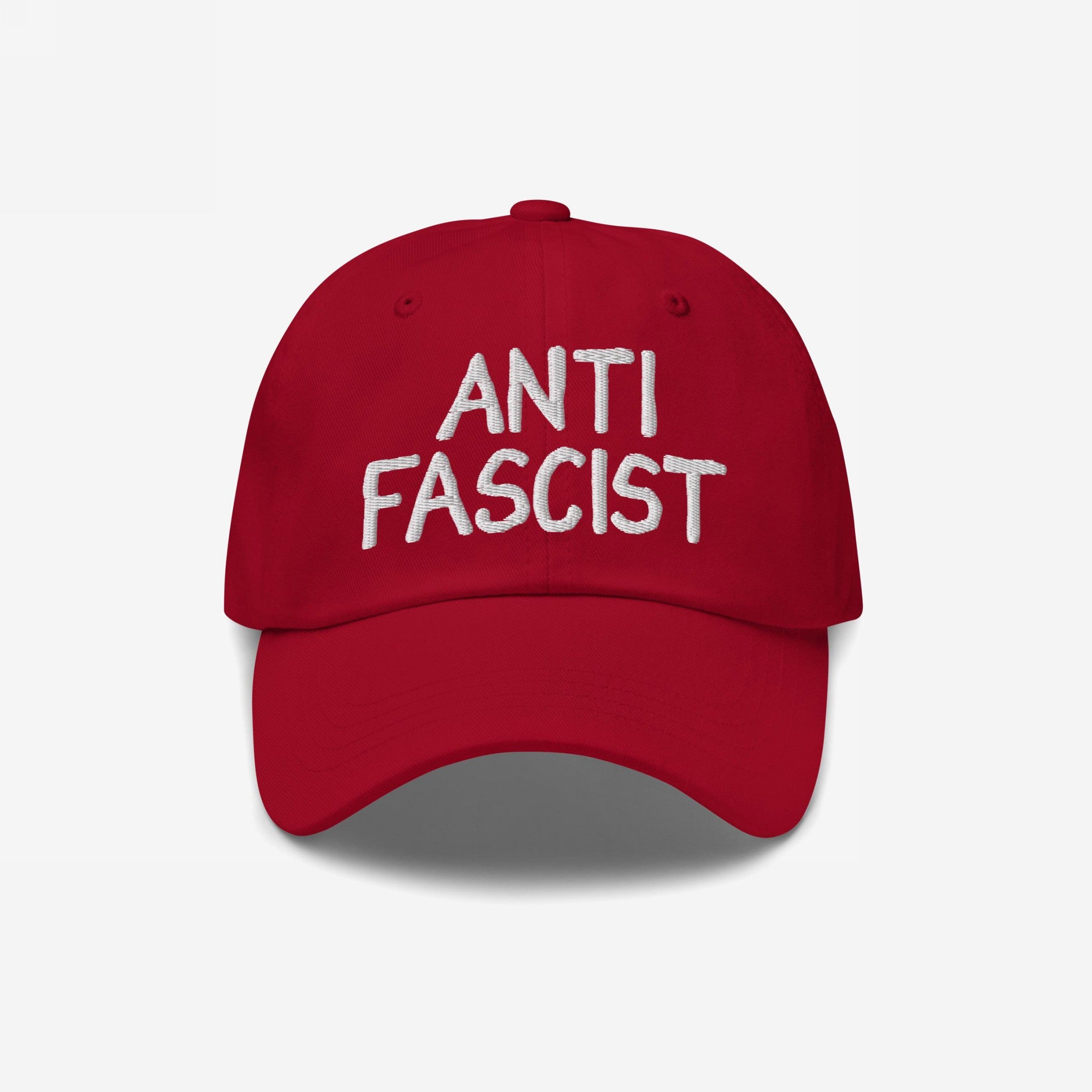 Anti Fascist Hat featuring ANTI FASCIST in white hand-drawn embroidery on a red baseball-style cap, embodying a stylish stand against fascism with everyday comfort and ethically made design.