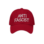 Anti Fascist Hat featuring ANTI FASCIST in white hand-drawn embroidery on a red baseball-style cap, embodying a stylish stand