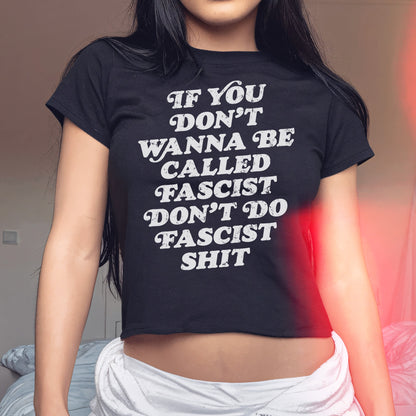 Anti-Fascist Retro Women's Baby Tee with bold slogan, If you don’t wanna be called fascist don’t do fascist shit, worn by a young woman, embodies a powerful statement for equality and activism.