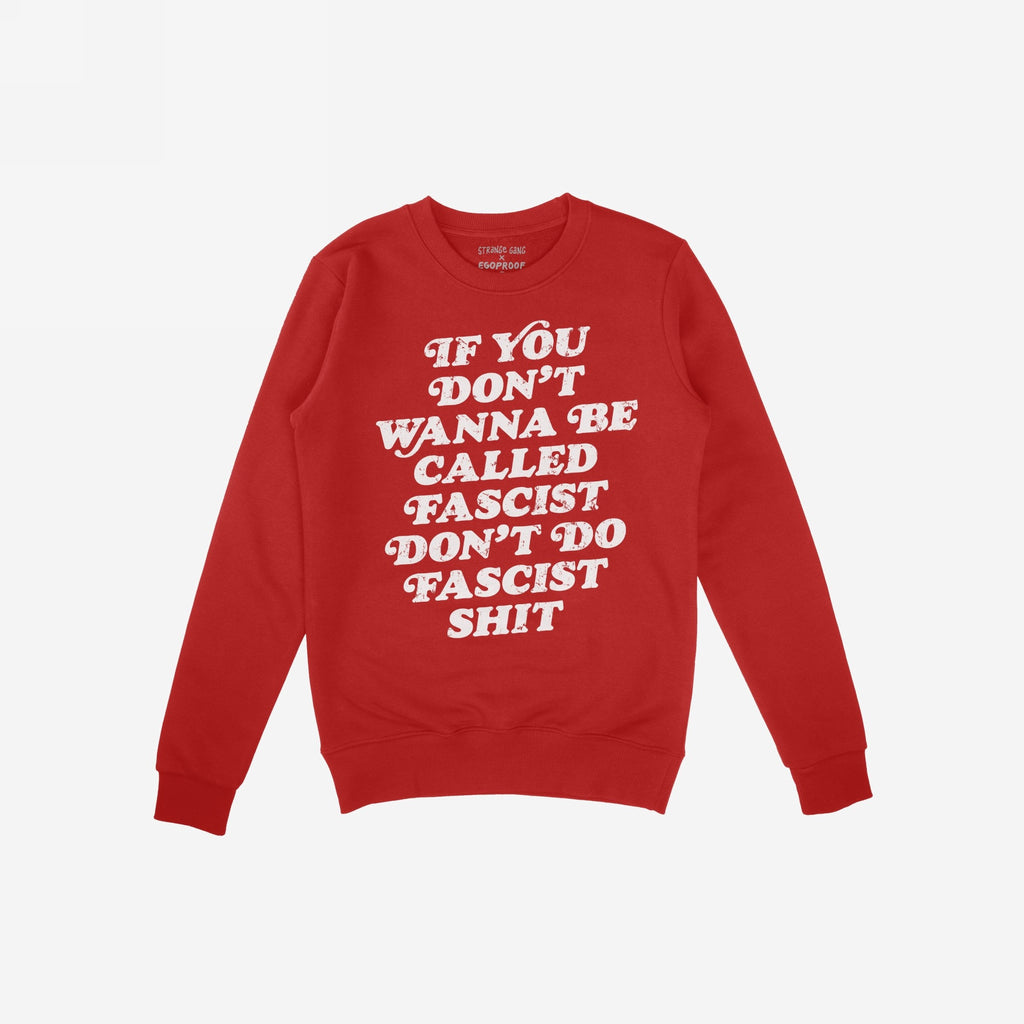 Red crewneck sweatshirt with “If you don’t wanna be called fascist, don’t do fascist shit” in white text across the front. Features Strange Gang x Egoproof label above the neckline.