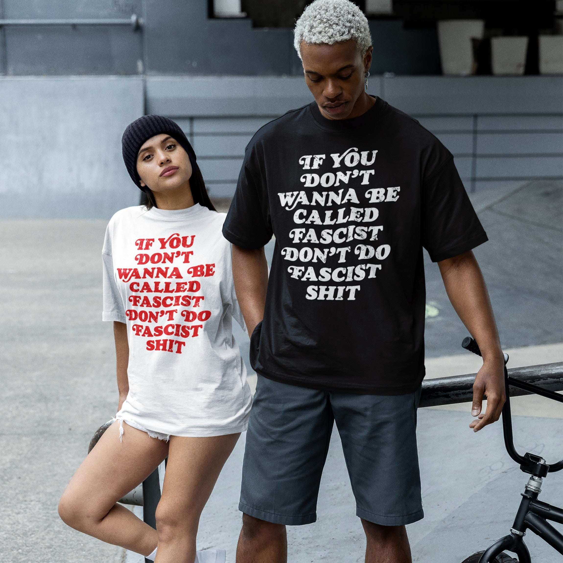 Anti-Fascist Retro Shirt displayed by two young adults in a skate park, featuring a bold slogan promoting resistance. One poses with a BMX bike, showcasing the shirt's empowering message.