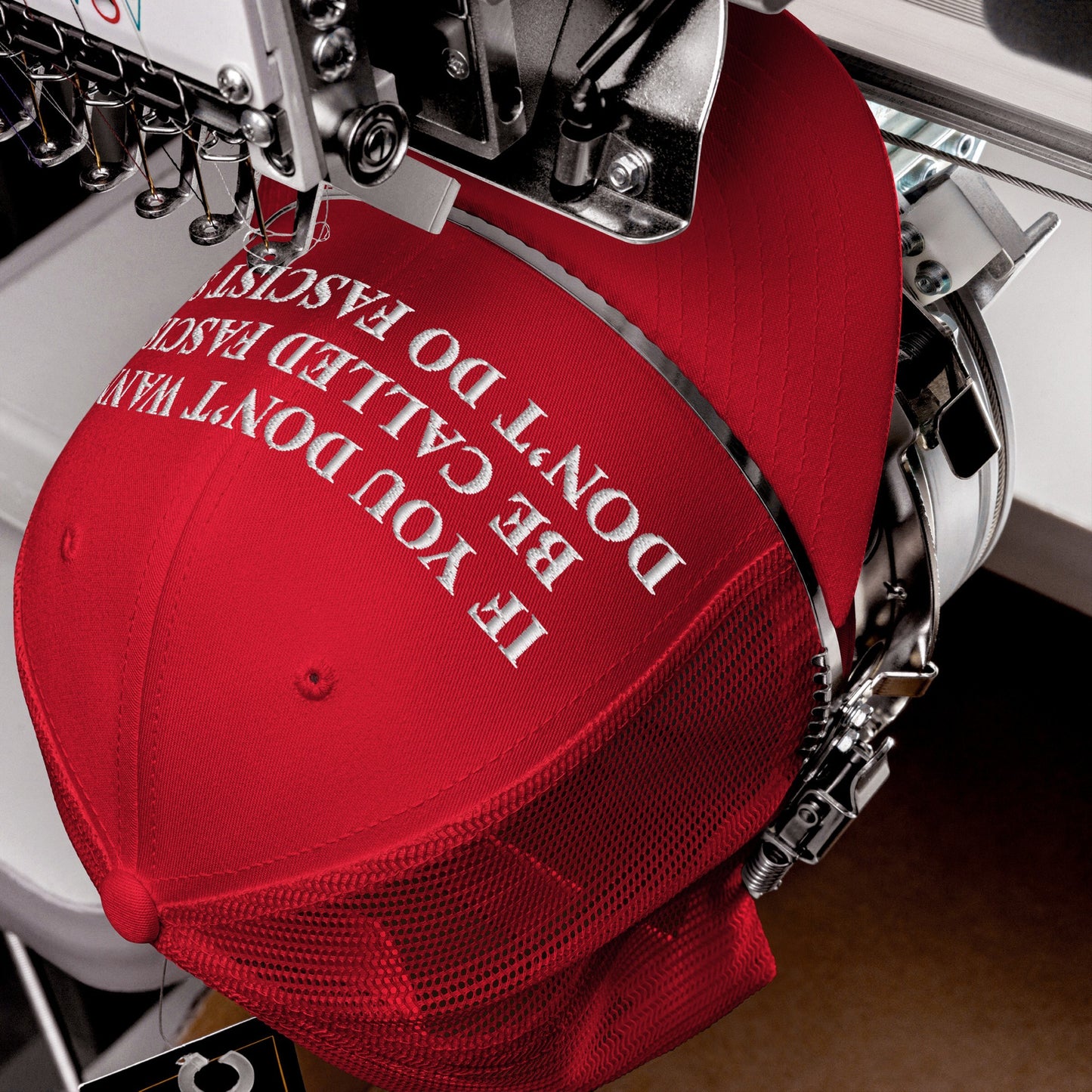Anti-Fascist Retro Hat in progress on an embroidery machine, showcasing bold text: “IF YOU DON’T WANT TO BE CALLED FASCIST, DON’T DO FASCIST.” A statement piece for those voicing resistance.
