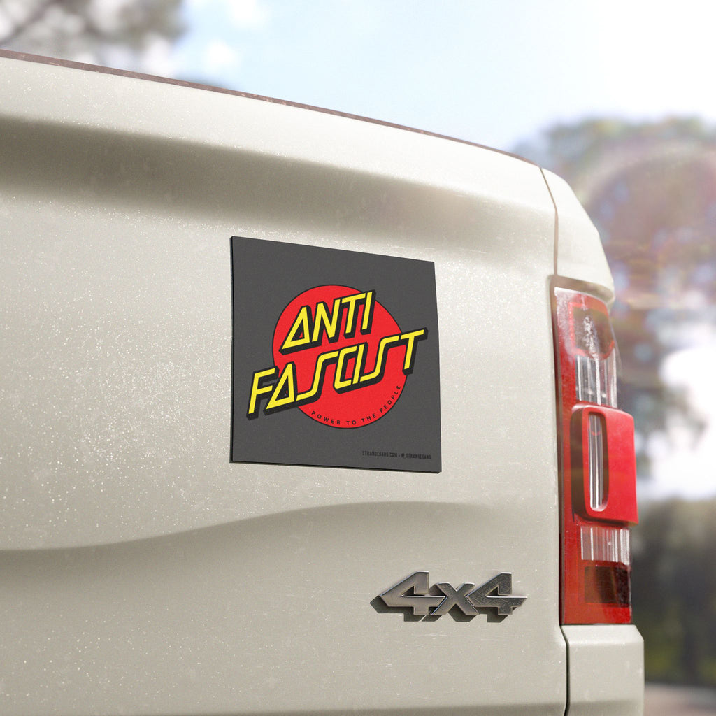 The tailgate of a light-colored 4×4 pickup displays the Anti Fascist Sticker & Magnet, featuring bold yellow text on a red circle, advocating Power To The People.