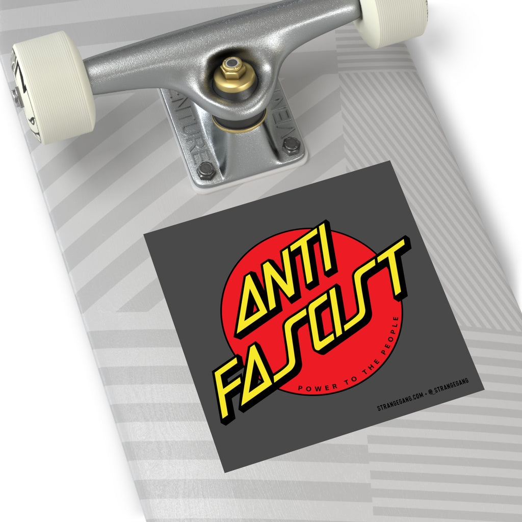 Skateboard deck with silver truck, white wheel, and a dark-gray Anti-Fascist sticker. The sticker features Power To The People text, representing progressive values and support for ACLU.