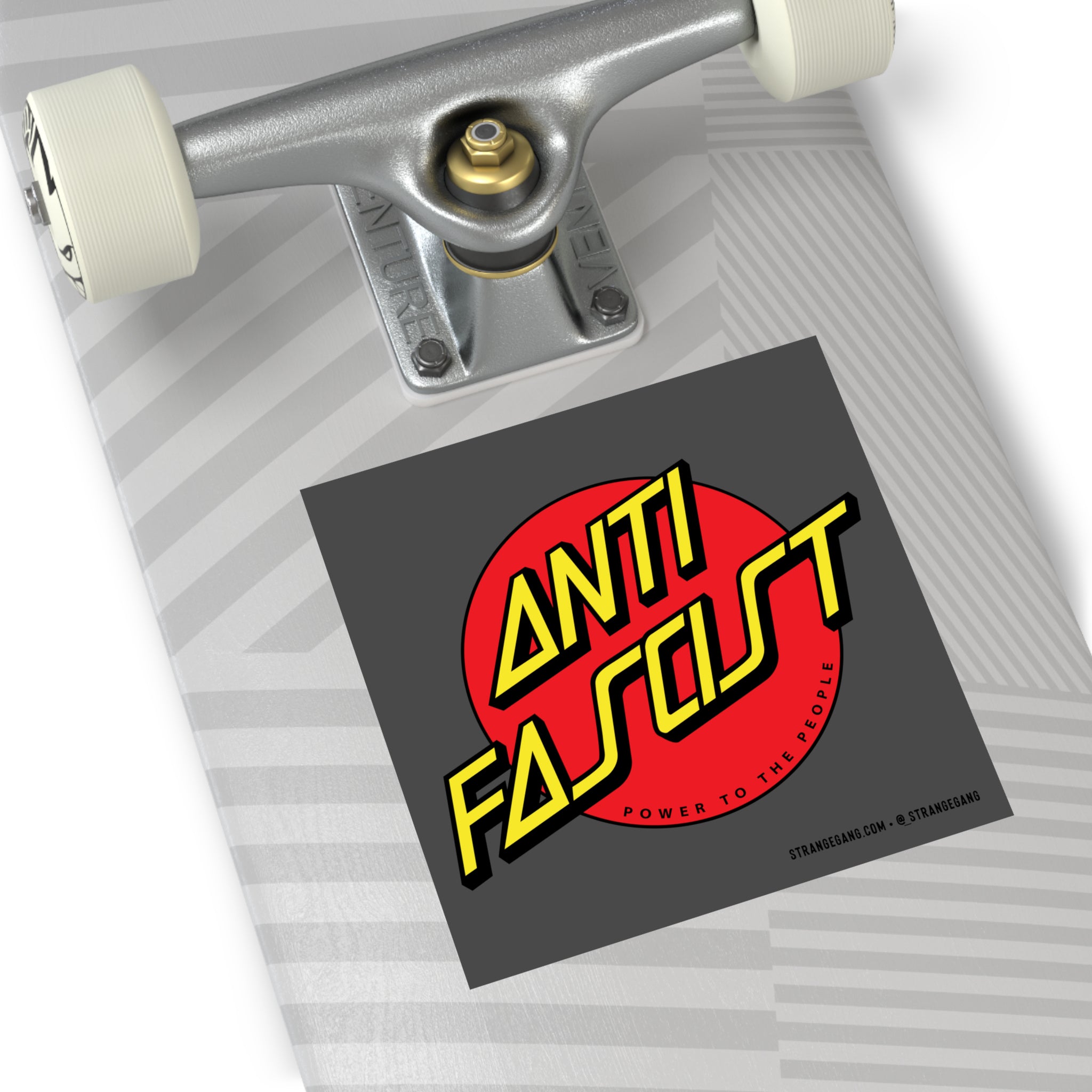 Skateboard deck with silver truck, white wheel, and a dark-gray Anti-Fascist sticker. The sticker features Power To The People text, representing progressive values and support for ACLU.