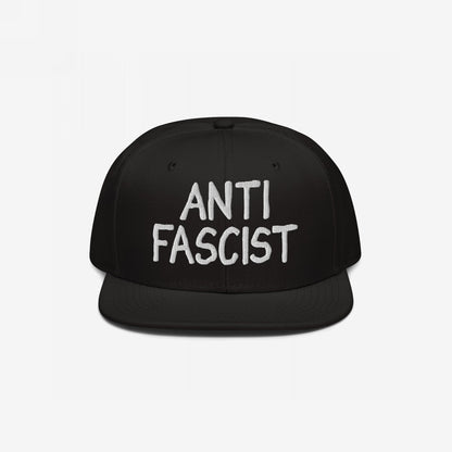 Anti-Fascist Hat: A black flat-brim cap featuring ANTI FASCIST in bold white embroidery. Ethically made and gender-free, it serves as a stylish statement against fascism.
