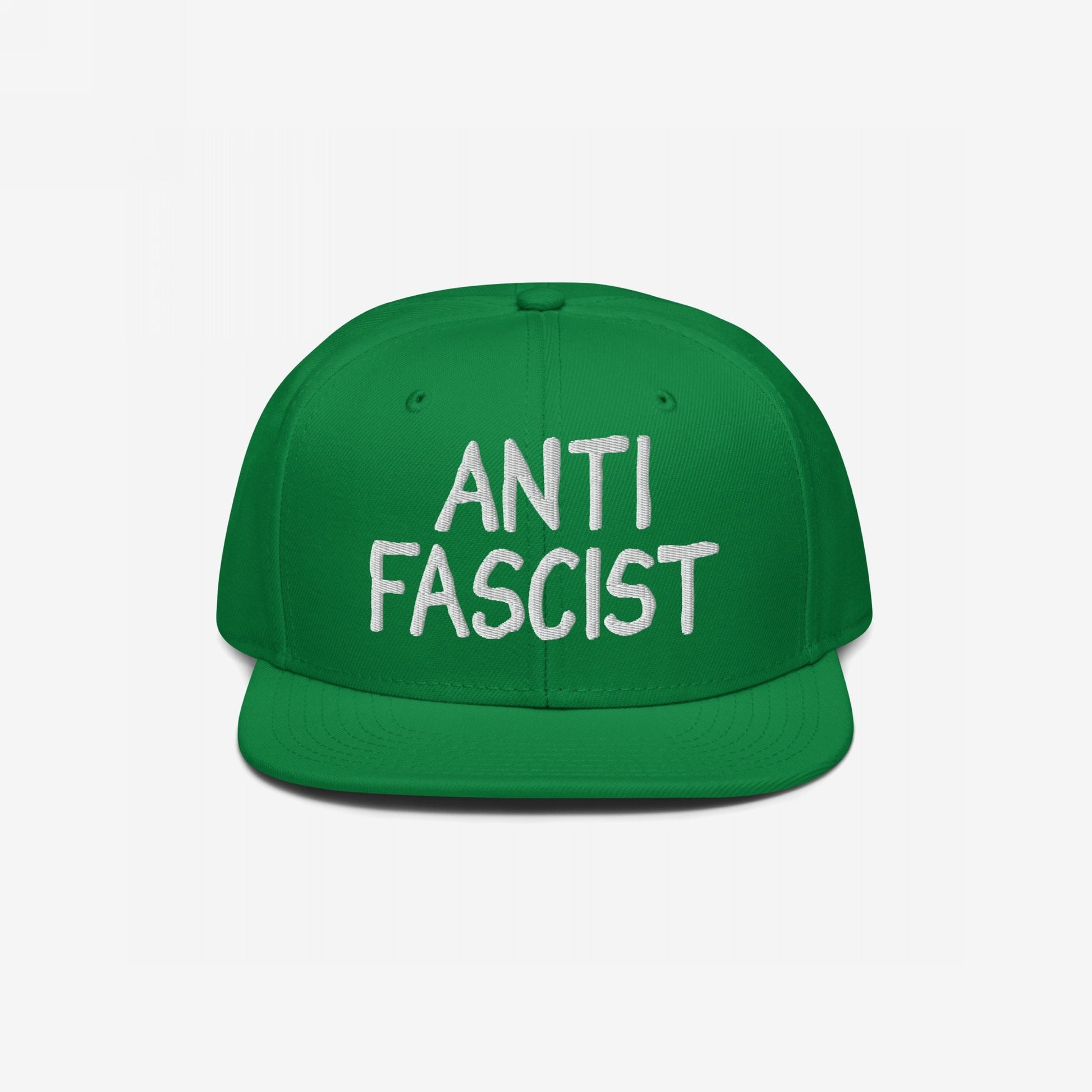 Green flat-brimmed snapback hat displaying ANTI FASCIST in white embroidery on the front, embodying a bold, ethically-made statement piece for equality and protest. Gender-free, supports Amnesty International.