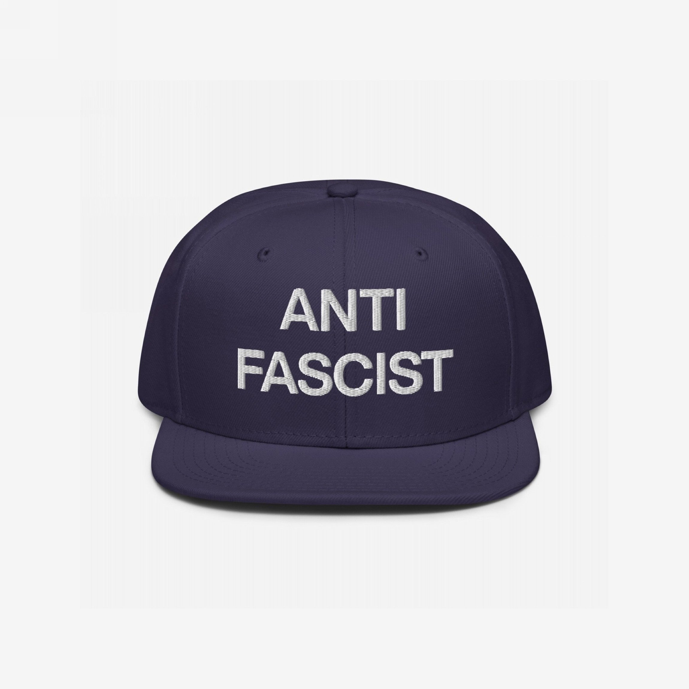 The Anti-Fascist Classic Hat features ANTI FASCIST in bold white embroidery on a navy-blue cap, embodying a strong message of resistance and timeless style.