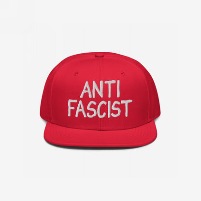 Red snapback with ANTI FASCIST in white embroidery, embodying a protest spirit. Ethically made, gender-free, and stylishly defiant, aligning with the ethos of equality and opposition to fascism.