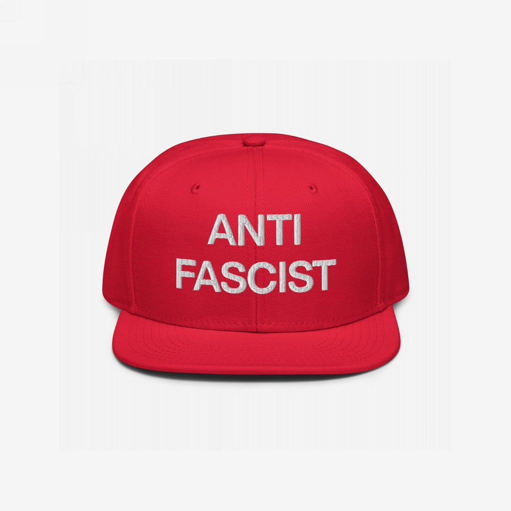The Anti-Fascist Classic Hat features bold white embroidery stating ANTI FASCIST on a red flat-brimmed baseball cap, embodying a strong, unapologetic stance against fascism with clean, striking lettering.