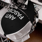 The Anti-Fascist Classic Hat in a commercial embroidery machine, featuring ANTI FASCIST stitched in white thread on the front, embodying bold resistance and timeless style.