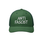 Green mesh-back trucker cap with a solid front panel, featuring ANTI FASCIST in bold white embroidery, symbolizing resistance