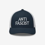 Navy-blue and white mesh trucker hat with “ANTI FASCIST” embroidered on the front, embodying style and resistance. Unisex design, ethically made, supporting the ACLU's mission against fascism.