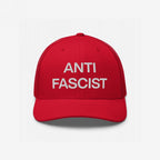 The Anti-Fascist Classic Hat features bold, white embroidered ANTI FASCIST lettering on a red trucker-style cap, embodying a clear stand against fascism with timeless style and conviction.