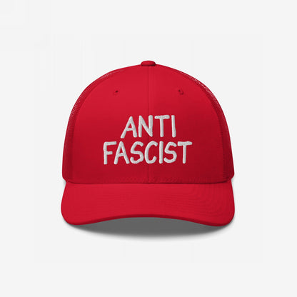 Red mesh-back trucker hat with white embroidered ANTI FASCIST lettering, embodying a bold yet understated protest style, ethically crafted for daily wear supporting equality and anti-fascism.